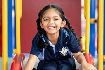 Primary school student on a slide smiling